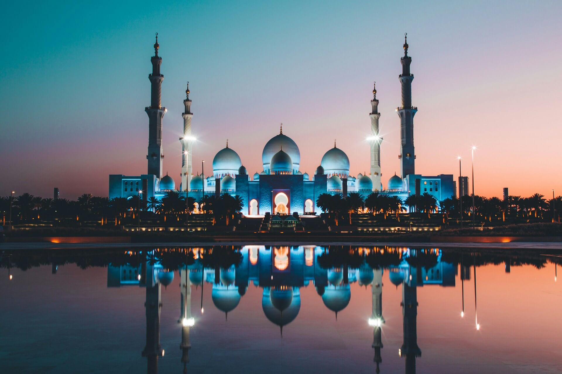 The white marble domes and reflecting pools of the Sheikh Zayed Grand Mosque in Abu Dhabi at dusk