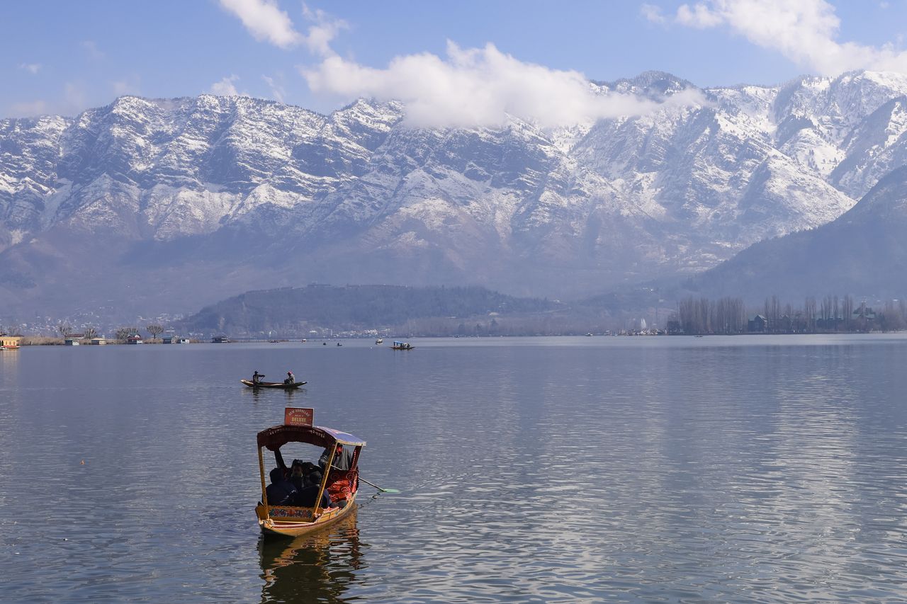 Shikara boats on Dal Lake at sunrise in Srinagar with the Zabarwan mountains behind, Kashmir
