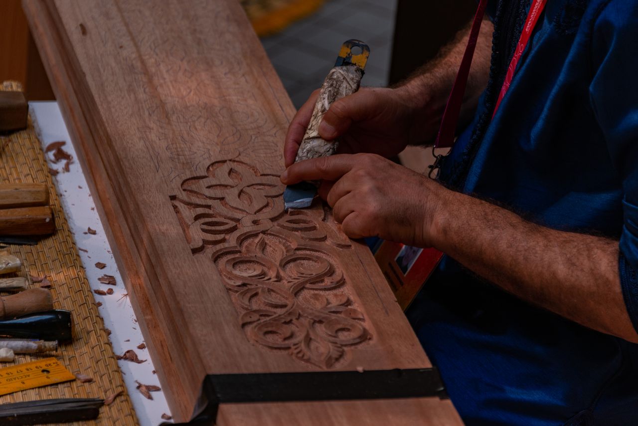 A Kashmiri artisan hand-painting papier mache and carving walnut wood in a Srinagar workshop